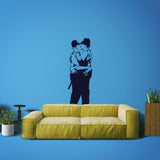 Police kissing wall sticker on a blue wall above a yellow couch.