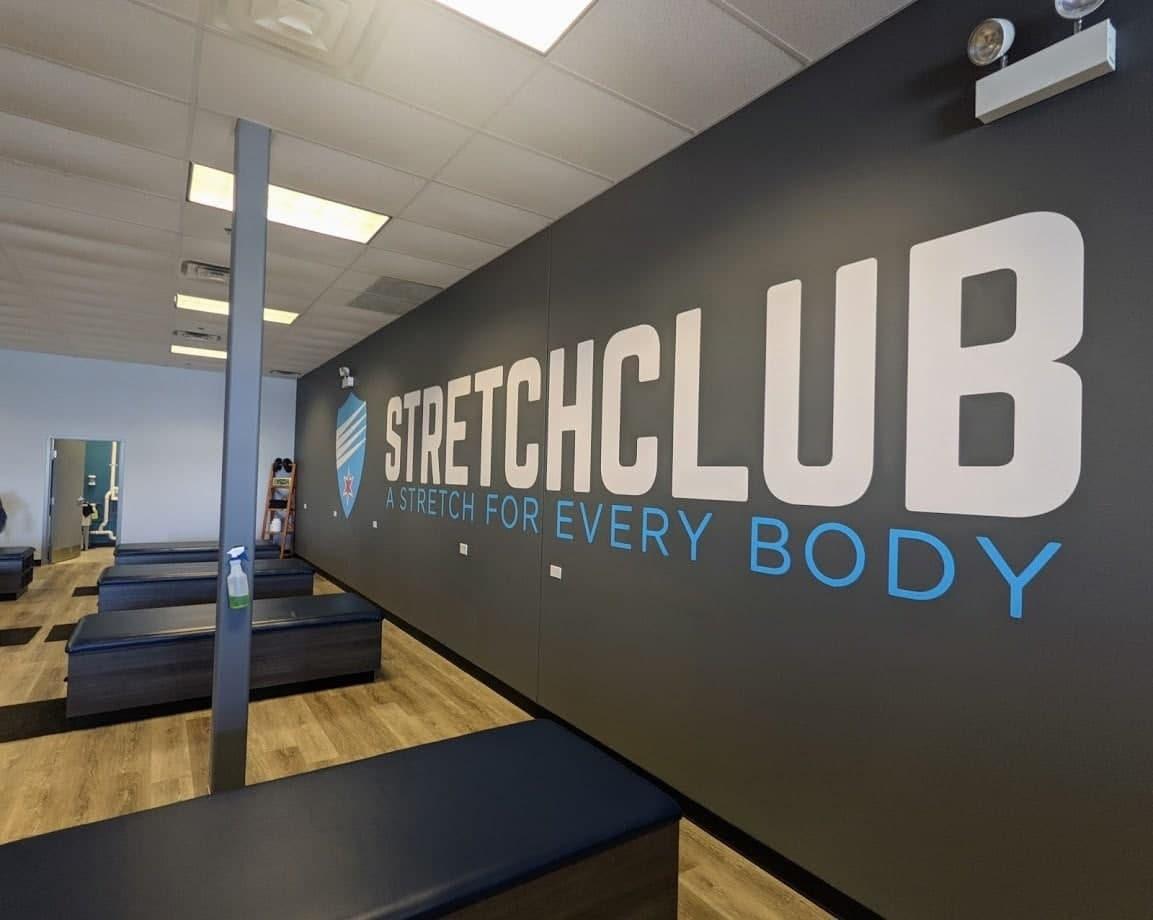 Custom fitness studio logo wall decal displayed above stretching tables.