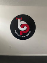 Custom fitness business logo wall decal displayed on a white wall.