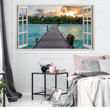3D window beach view wall sticker featuring a tranquil ocean scene with a wooden pier and sunset in a bedroom setting.
