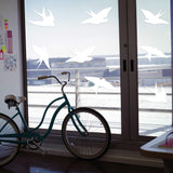 Frosted bird strike window decals on glass, showcasing decorative design and safety features to prevent bird collisions.