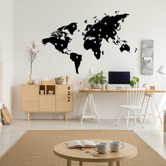Large black world map wall decal in a modern home office setting, adding a stylish touch to the decor.