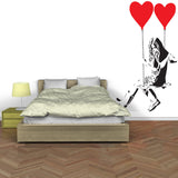 Girl with heart balloon wall sticker displayed above a bed.