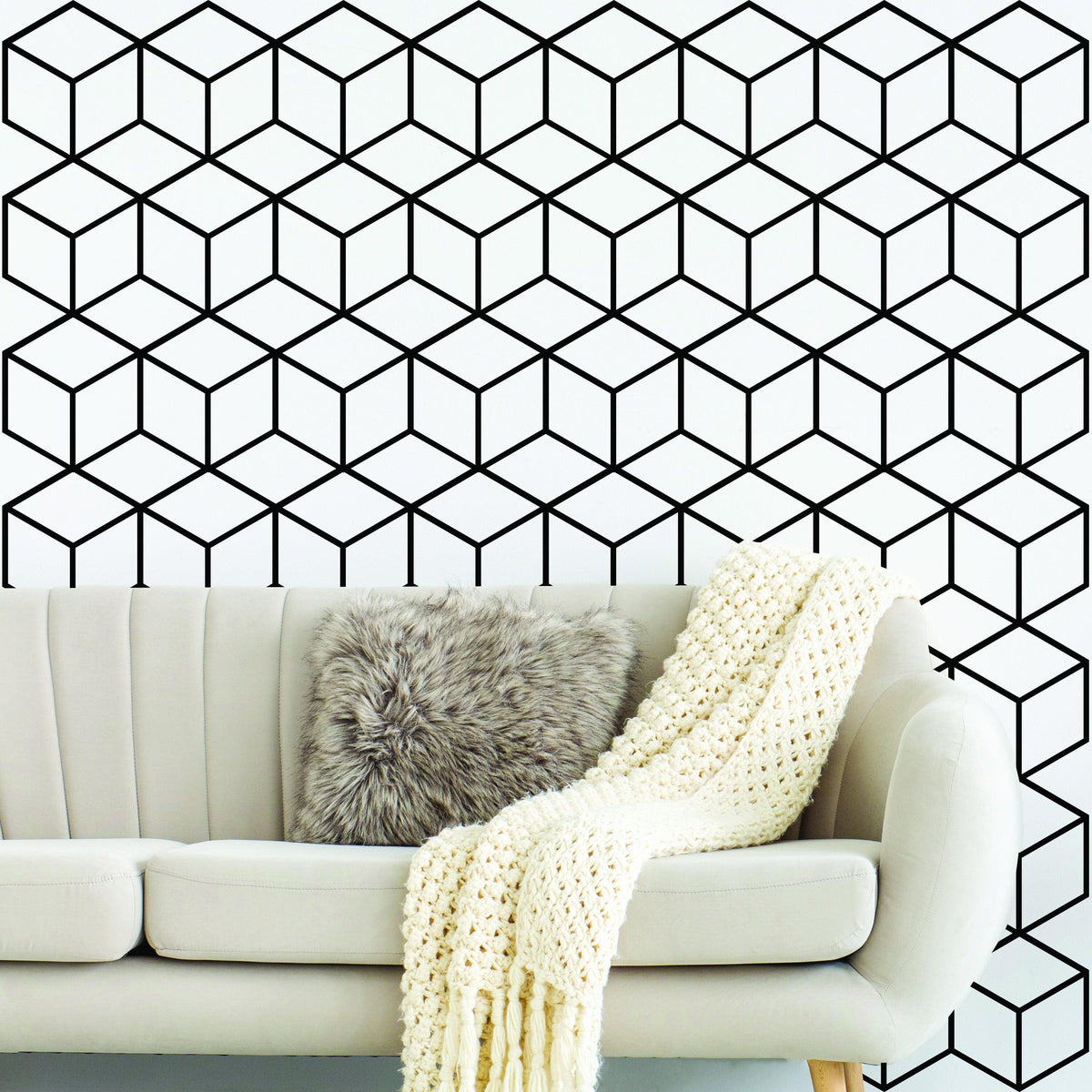 Geometric black and white hexagon honeycomb wall mural in modern living room with cozy sofa and decorative throw.