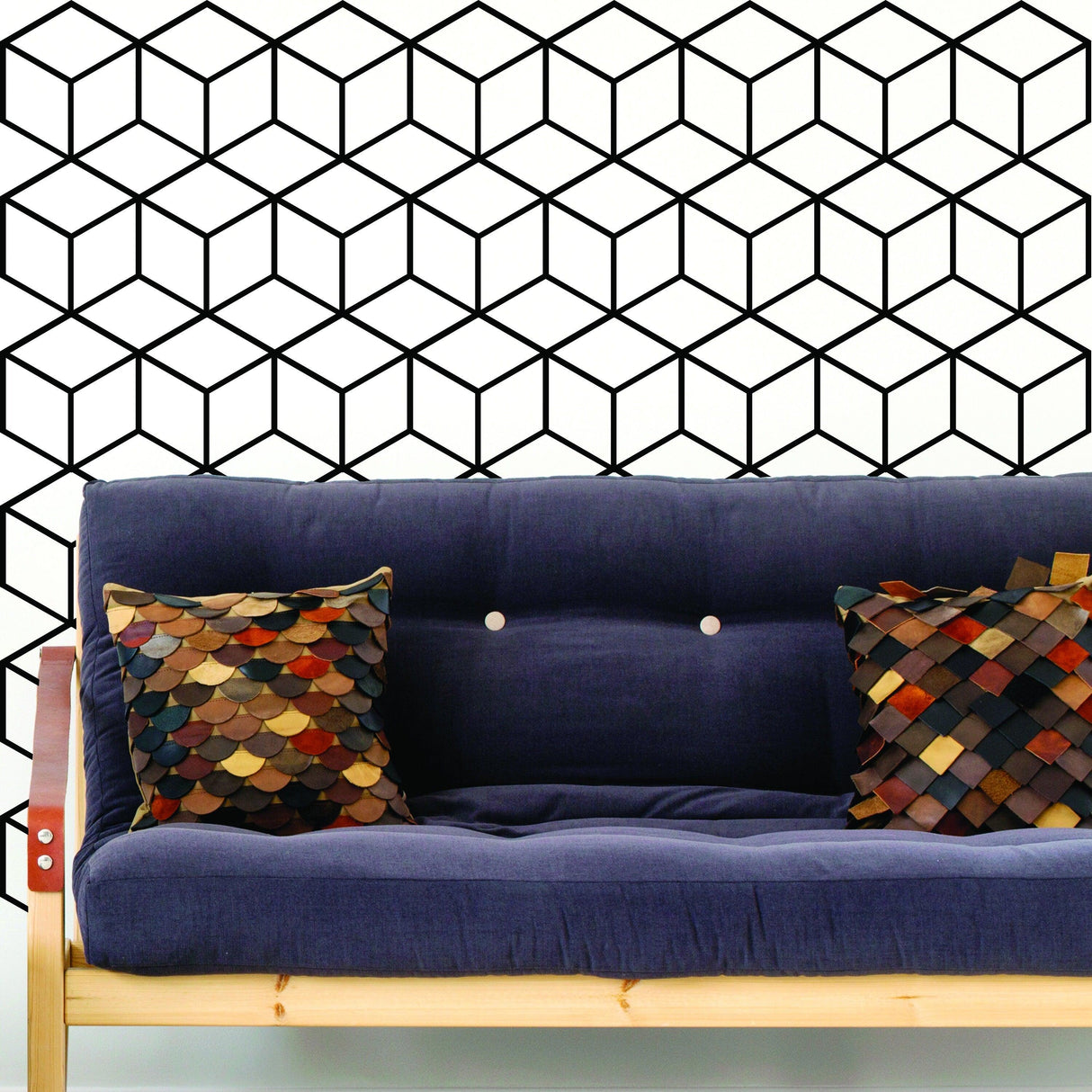 Geometric wall mural decal featuring a hexagon honeycomb design behind a blue couch with decorative pillows.