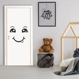 Smiling face decal on a white door in a child's room with a teddy bear and decorative elements.