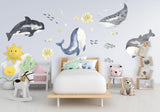 Ocean whales wall sticker decor in a baby boy nursery with playful undersea scene and vibrant colors.