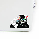 Glow in the dark monkey laptop vinyl sticker with colorful headphones for music lovers.