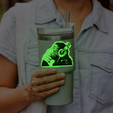 Person holding a Glow in the Dark Monkey sticker on a cup.