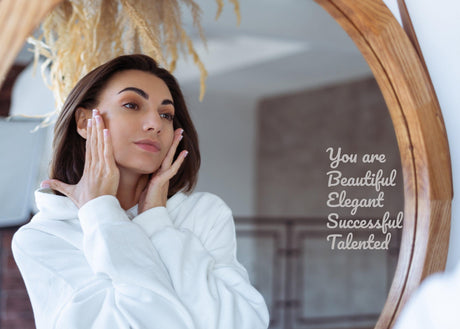 Woman looking into a mirror with the affirmation decal “You are Beautiful, Elegant and Successful.”