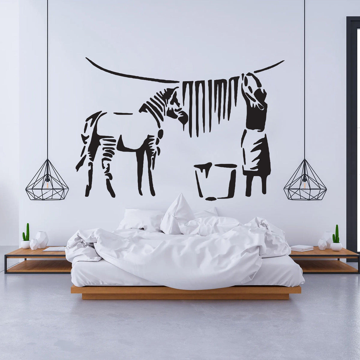 Banksy zebra stripes wall decal in modern bedroom with white bedding and geometric hanging lights.