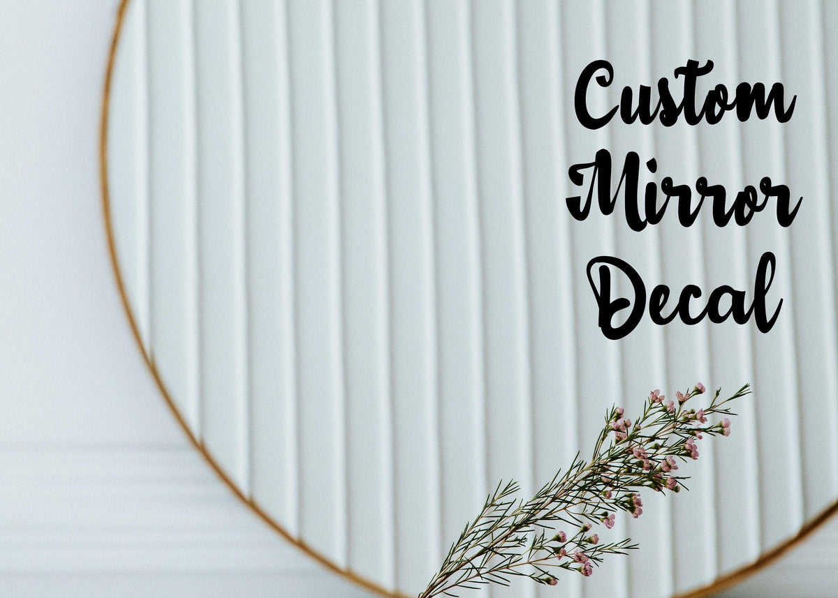 Custom mirror decal on a decorative round mirror with a floral accent.