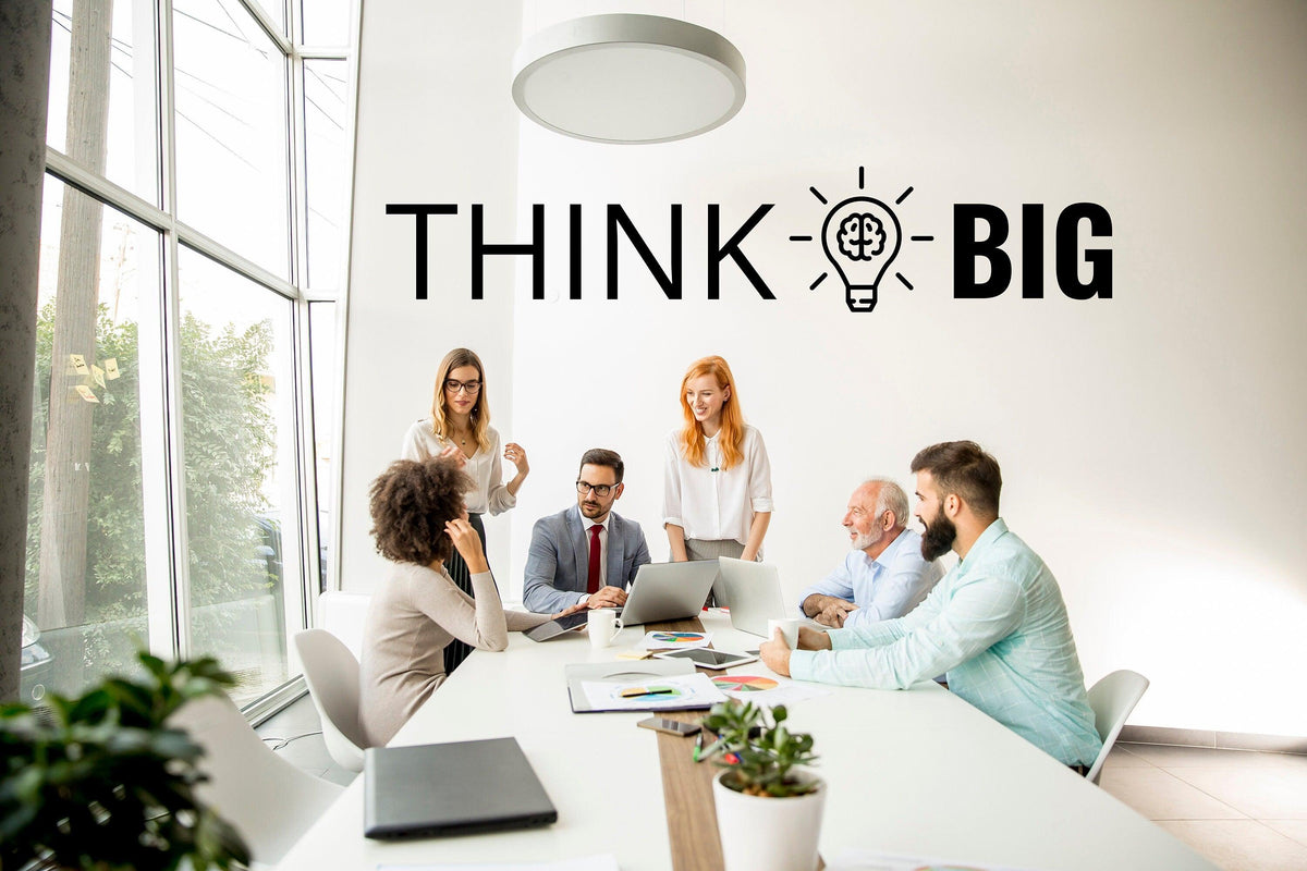 Надпись THINK BIG на стене рабочего пространства.