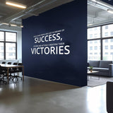 Inspirational wall art decal in home office featuring motivational quote about success and victories.