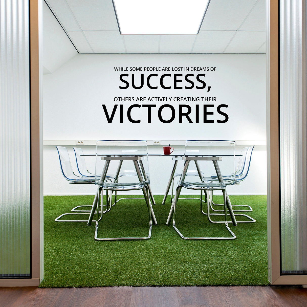 Inspirational wall art decal with motivational quote about success and victories in a modern office setting.