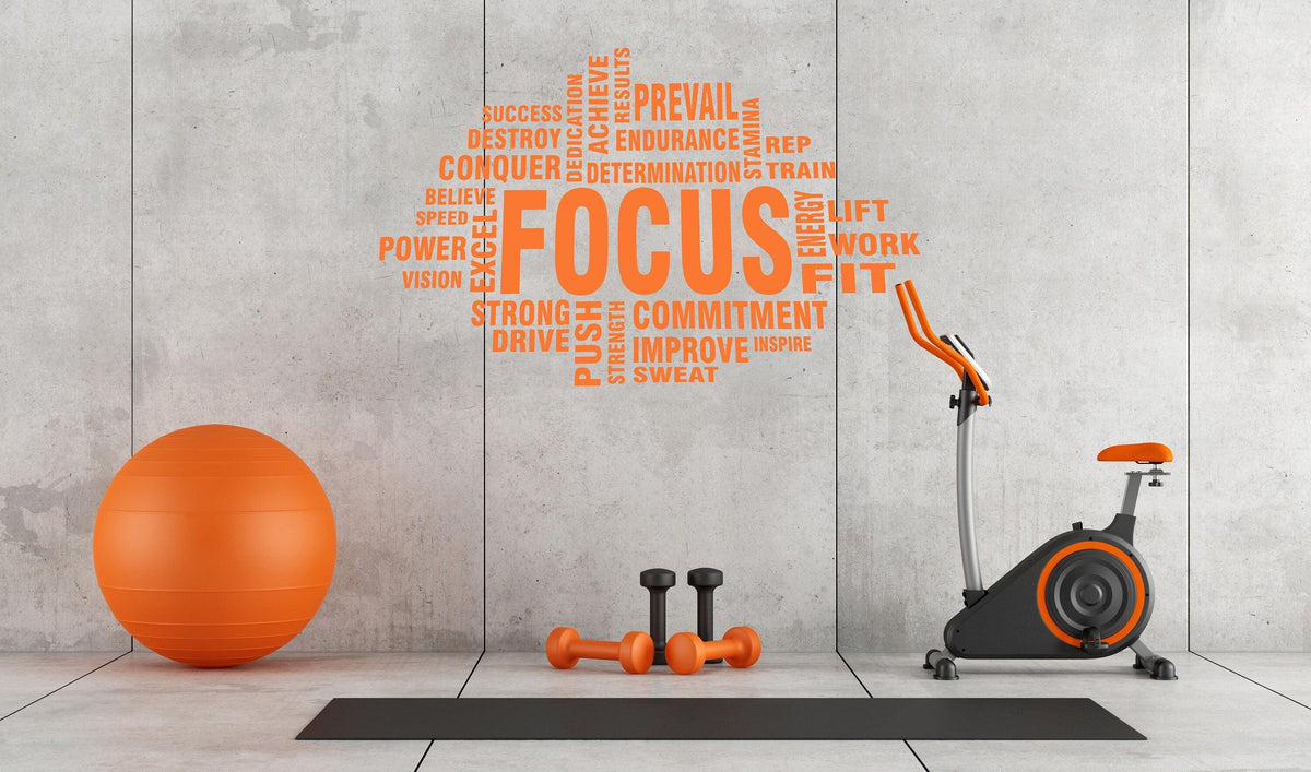 Motivational gym wall decal featuring the word 'FOCUS' with fitness-related terms in an orange theme.