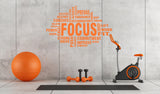 Motivational gym wall decal featuring the word 'FOCUS' with fitness-related terms in an orange theme.