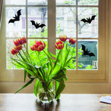 Halloween bats window decals on a home window with tulips.