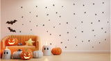 Spooky spider wall art stickers in a festive Halloween-themed living room with pumpkins and bats.