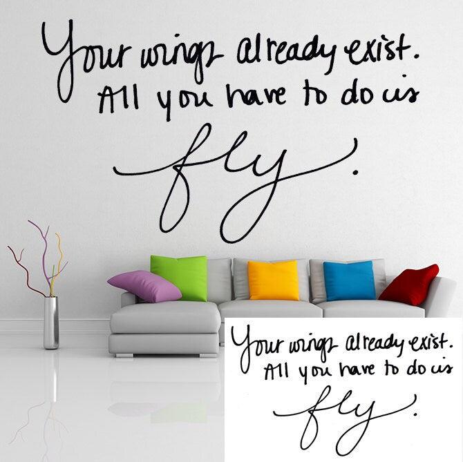 Stylish vinyl decal of the quote 'Your wings already exist. All you have to do is fly.' in a modern living room.